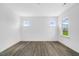 Bright bedroom featuring two windows and modern gray flooring at 1029 Dillon Lake Dr, Knightdale, NC 27545