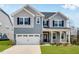 Charming two-story home with blue siding, white trim, covered porch, and attached two car garage at 1029 Dillon Lake Dr, Knightdale, NC 27545