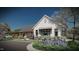 Charming exterior showcasing white siding, black windows, and a welcoming porch, complemented by blooming flowers and lush landscaping at 1029 Dillon Lake Dr, Knightdale, NC 27545