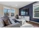 Modern living area with sectional sofa, large TV, and wood-look flooring at 1040 Myers Point Dr, Morrisville, NC 27560