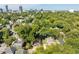 Aerial showing a blue house nestled in a neighborhood with a city skyline in the distance at 105 Cooke St, Raleigh, NC 27601