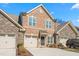 Brick front exterior of charming townhome with two-car garage and landscaped yard at 1099 Talisker Way, Burlington, NC 27215