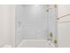 Bathroom with modern features, including sleek tiling, brass hardware, and a glass-enclosed shower-tub combo at 1608 Legacy Ridge Ln, Wake Forest, NC 27587