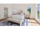 Sunlit bedroom boasts a cozy ambiance with a large rug, bench, and natural light pouring through the windows at 1608 Legacy Ridge Ln, Wake Forest, NC 27587