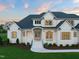 Inviting white two-story home with dark roof, landscaped front yard, and welcoming entrance at dusk at 1608 Legacy Ridge Ln, Wake Forest, NC 27587