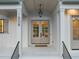 Elegant front entryway featuring double doors, stylish lighting, and beautiful stonework at 1608 Legacy Ridge Ln, Wake Forest, NC 27587