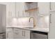 Bright kitchen features white cabinets, gold hardware, stainless steel appliances, and neutral backsplash at 1608 Legacy Ridge Ln, Wake Forest, NC 27587