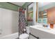 Well-lit bathroom with a shower-tub, white sink vanity, and a window offering natural light and style at 211 Dwelling Pl, Knightdale, NC 27545