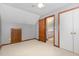 Bedroom with a cozy atmosphere, closet, carpeting, and a doorway to another room enhancing accessibility at 211 Dwelling Pl, Knightdale, NC 27545