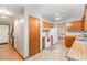 Open concept kitchen with wood cabinets, white appliances, and connecting doorway at 211 Dwelling Pl, Knightdale, NC 27545