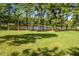 Lush backyard with mature trees and a serene pond at 2223 Grove Hill Rd, Franklinton, NC 27525