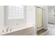 Bathroom with a bathtub, shower, and a window at 2730 Erinridge Rd, Raleigh, NC 27610
