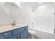 Bathroom with blue vanity, tub, and a round mirror at 2730 Erinridge Rd, Raleigh, NC 27610