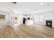 Open living room with fireplace, kitchen island, and wood-look floors at 2730 Erinridge Rd, Raleigh, NC 27610