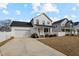 Two-story farmhouse features white siding, a front porch, and a two-car garage at 308 W Hill St, Benson, NC 27504