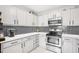 Modern kitchen with white cabinets, black hardware, stainless steel oven, and a mosaic tile backsplash at 501 Pearson Dr, Durham, NC 27713