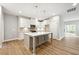 Bright kitchen featuring white cabinets, quartz countertops and an island with pendant lighting at 5394 Salem Woods Dr # 16, Graham, NC 27253