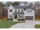 Two story white brick home with gray roof and a 3-car garage at 8101 Fergus Ct, Wake Forest, NC 27587