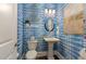 Modern powder room with a pedestal sink and blue patterned walls at 8101 Fergus Ct, Wake Forest, NC 27587