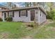 Gray duplex unit with a dark door, stone steps, and grassy yard at 830 E Lenoir St, Raleigh, NC 27601