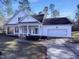 White house with front porch, two-car garage, and landscaping at 1004 Cabin Hill Way, Garner, NC 27529