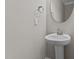 Small bathroom with pedestal sink, round mirror, and modern fixtures at 104 Spruce Hollow Cir, Spring Lake, NC 28390
