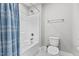 Clean bathroom with a shower/tub combo and blue striped shower curtain at 104 Spruce Hollow Cir, Spring Lake, NC 28390
