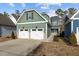 Two-story house with green siding, two-car garage, and a landscaped yard at 104 Spruce Hollow Cir, Spring Lake, NC 28390