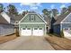 Two-story house with green siding, two-car garage, and a landscaped yard at 104 Spruce Hollow Cir, Spring Lake, NC 28390