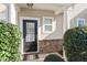 Inviting entrance features a black front door, stone accents, and mature landscaping at 11215 Lofty Heights Pl, Raleigh, NC 27614
