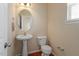 Charming powder room with pedestal sink, oval mirror, and wood floors at 11215 Lofty Heights Pl, Raleigh, NC 27614