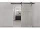 Bright bathroom seen through sliding barn door, features a vanity and tiled floors at 205 Spring St, Louisburg, NC 27549