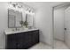 Bathroom boasts a double vanity with framed mirrors, stylish lighting fixtures, and marble countertops at 205 Spring St, Louisburg, NC 27549