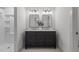 Bathroom features a double vanity with framed mirrors, stylish lighting, and a walk-in shower at 205 Spring St, Louisburg, NC 27549