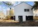 Backyard view featuring a newly constructed deck with stairs, and additional access to the basement via exterior doors at 205 Spring St, Louisburg, NC 27549