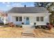 Charming home featuring a cheerful light blue front door and a cozy, inviting entryway with symmetrical windows and columns at 205 Spring St, Louisburg, NC 27549