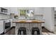 Bright kitchen showcasing white cabinets, modern appliances, butcher block island, and large windows providing natural light at 205 Spring St, Louisburg, NC 27549