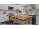 Charming kitchen featuring white cabinets, stainless steel appliances, and unique butcher block island with seating at 205 Spring St, Louisburg, NC 27549