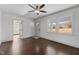 Inviting living room with hardwood floors, large windows, and a ceiling fan providing ample light at 205 Spring St, Louisburg, NC 27549