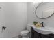 Charming powder room features a vanity with a round mirror, a stylish faucet, and patterned tile floors at 205 Spring St, Louisburg, NC 27549