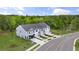 Aerial view of three townhouses, showcasing a pond and lush landscaping at 22 Virgo Dr, Angier, NC 27501