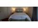 Comfortable bedroom with a well-made bed, bedside lamps, and bench seating at 223 N Main St, Wendell, NC 27591