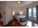 Bright bedroom with a well-made bed, bedside lamps, hardwood floors, and natural light at 223 N Main St, Wendell, NC 27591