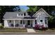 Charming single-Gathering home with a inviting front porch, beautiful landscaping and American flag at 223 N Main St, Wendell, NC 27591