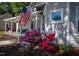 Charming home exterior with an American flag and colorful azaleas along walkway at 223 N Main St, Wendell, NC 27591
