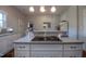 Kitchen island with sleek cooktop, white cabinetry, and counter seating at 223 N Main St, Wendell, NC 27591