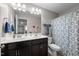 Well-lit bathroom featuring a double sink vanity, large mirror, and a shower with patterned curtain at 241 Fair Oaks Ct, Mebane, NC 27302