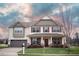 Charming two-story home featuring a well-manicured lawn, attached garage, and inviting front porch area at 241 Fair Oaks Ct, Mebane, NC 27302