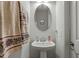 Small bathroom with pedestal sink and oval mirror at 386 Cotton Brook Dr, Fuquay Varina, NC 27526
