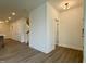 Bright living room features wood-look floors, neutral walls and trim, and access to the stairway and other rooms at 494 Traditions Grande Blvd # 25, Wake Forest, NC 27587